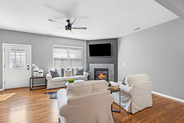 6166 Albany Crest Ave, New Albany, OH 43054 - living room featuring a fireplace, ceiling fan, healthy amount of natural light, wood finished floors, and a textured ceiling