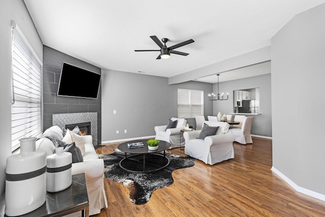 6166 Albany Crest Ave, New Albany, OH 43054 - living area featuring a ceiling fan, a tiled fireplace, wood finished floors, and a chandelier
