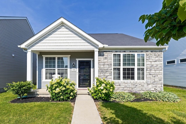 5442 Goose Falls Dr, Dublin, OH 43016 - view of front of home with stone siding, a front yard, and a shingled roof