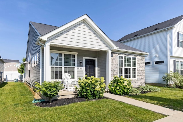 5442 Goose Falls Dr, Dublin, OH 43016 - view of front of house with a front lawn, stone siding, and covered porch