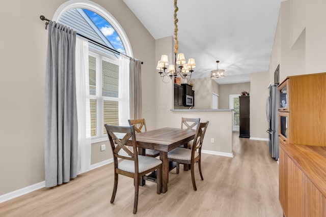5442 Goose Falls Dr, Dublin, OH 43016 - dining area with a chandelier, light wood finished floors, and lofted ceiling