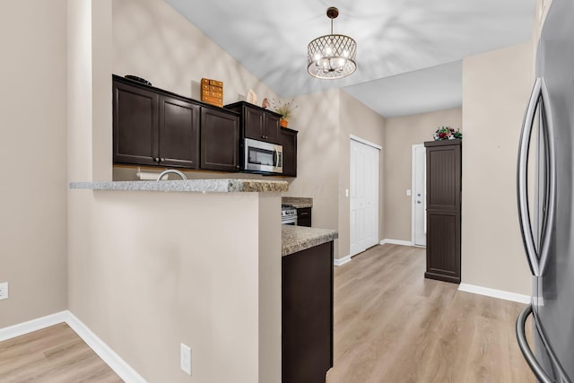 5442 Goose Falls Dr, Dublin, OH 43016 - kitchen with stainless steel appliances, light wood-style flooring, a chandelier, dark brown cabinetry, and decorative light fixtures