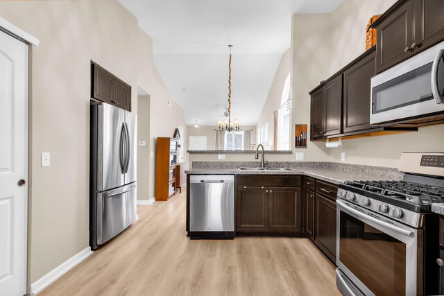 5442 Goose Falls Dr, Dublin, OH 43016 - kitchen featuring appliances with stainless steel finishes, dark brown cabinetry, a chandelier, and lofted ceiling