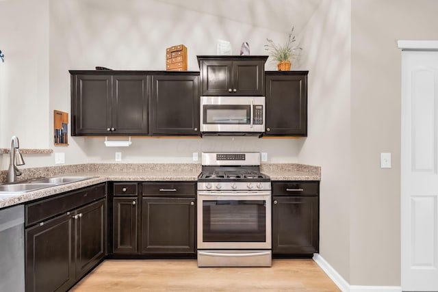 5442 Goose Falls Dr, Dublin, OH 43016 - kitchen featuring appliances with stainless steel finishes, light wood finished floors, light countertops, and dark brown cabinetry
