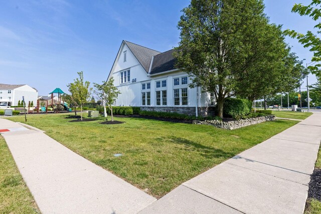 5442 Goose Falls Dr, Dublin, OH 43016 - view of side of home with a lawn, stone siding, and roof with shingles
