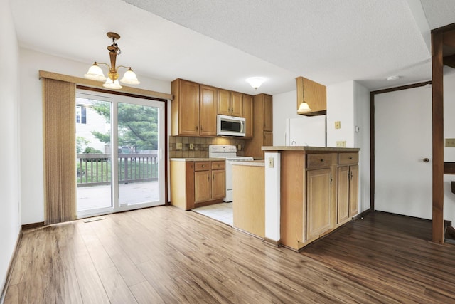 5062 Stoneybrook Blvd Unit 3F, Hilliard, OH 43026 - kitchen with white appliances, wood finished floors, brown cabinetry, and a textured ceiling