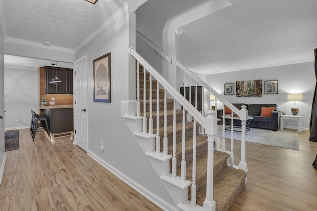 13680 Nantucket Ave NW, Pickerington, OH 43147 - stairs with a textured ceiling, wood finished floors, ornamental molding, and baseboards