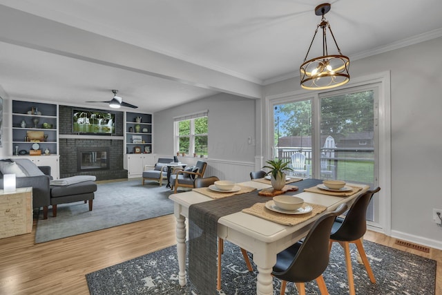 13680 Nantucket Ave NW, Pickerington, OH 43147 - dining area featuring a chandelier, wood finished floors, a brick fireplace, ceiling fan, and crown molding