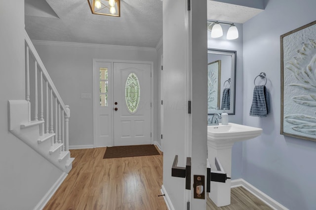 13680 Nantucket Ave NW, Pickerington, OH 43147 - foyer entrance with wood finished floors, a textured ceiling, stairway, baseboards, and ornamental molding