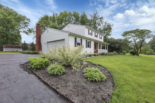 13680 Nantucket Ave NW, Pickerington, OH 43147 - view of front facade featuring a front lawn, a garage, asphalt driveway, and a porch