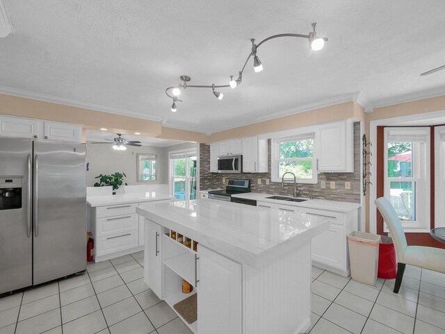 832 Lynnfield Dr, Westerville, OH 43081 - kitchen with stainless steel appliances, crown molding, light tile patterned floors, white cabinets, and a center island