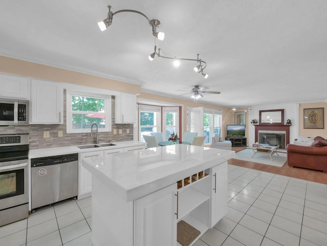 832 Lynnfield Dr, Westerville, OH 43081 - kitchen with stainless steel appliances, light tile patterned floors, light countertops, white cabinetry, and ornamental molding