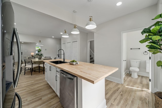591 S 22nd St, Columbus, OH 43205 - kitchen with refrigerator, butcher block counters, dishwasher, light wood-style floors, and white cabinetry