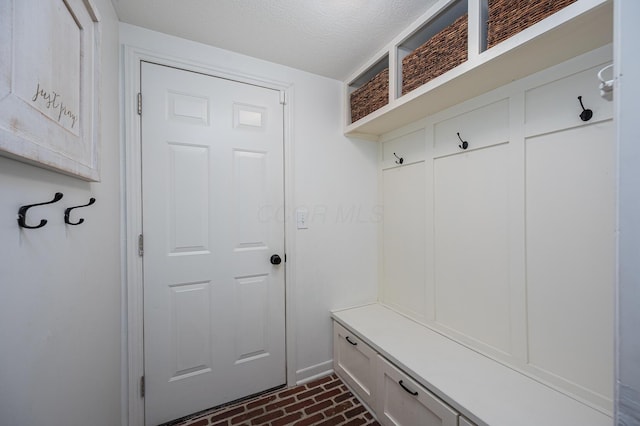 1355 Fisher Run Ct, Columbus, OH 43235 - mudroom featuring brick floors and a textured ceiling