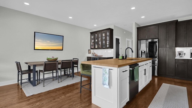 1098 Oregon Ave, Columbus, OH 43201 - kitchen featuring dishwasher, wooden counters, stainless steel fridge, decorative backsplash, and a center island with sink