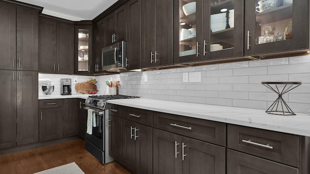 1098 Oregon Ave, Columbus, OH 43201 - kitchen featuring stainless steel appliances, dark brown cabinets, dark wood finished floors, light stone counters, and decorative backsplash