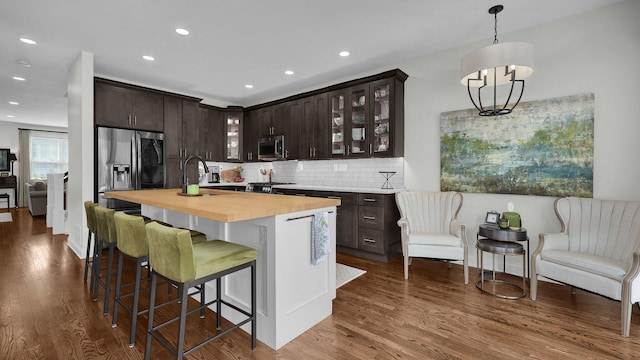 1098 Oregon Ave, Columbus, OH 43201 - kitchen featuring appliances with stainless steel finishes, dark brown cabinetry, dark wood finished floors, tasteful backsplash, and wooden counters
