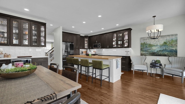 1098 Oregon Ave, Columbus, OH 43201 - kitchen featuring appliances with stainless steel finishes, dark brown cabinetry, wine cooler, butcher block counters, and backsplash