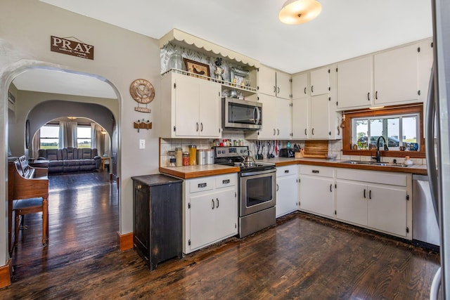 2380 Cedar Hill Rd SW, Amanda, OH 43102 - kitchen with appliances with stainless steel finishes, dark wood finished floors, backsplash, and arched walkways
