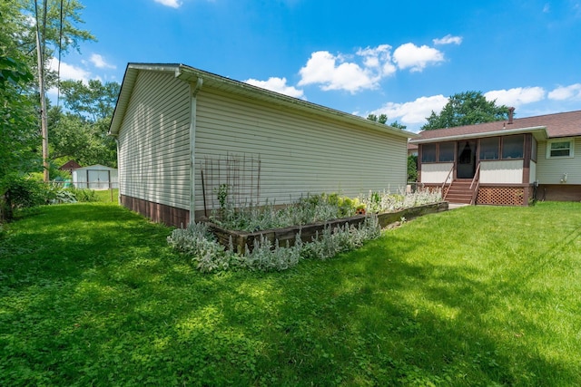 591 Knights Ave, Columbus, OH 43230 - view of home's exterior featuring a sunroom, a lawn, and a garden