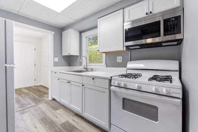 334 S Richardson Ave, Columbus, OH 43204 - kitchen featuring gas range gas stove, stainless steel microwave, light wood finished floors, and white cabinetry