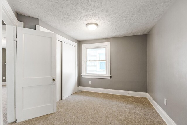 334 S Richardson Ave, Columbus, OH 43204 - unfurnished bedroom featuring light carpet, a closet, and a textured ceiling