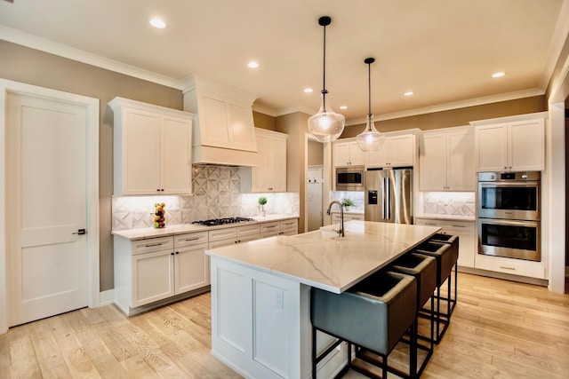 8210 Lilium Way, Plain City, OH 43064 - kitchen with stainless steel appliances, white cabinets, a sink, light stone counters, and ornamental molding