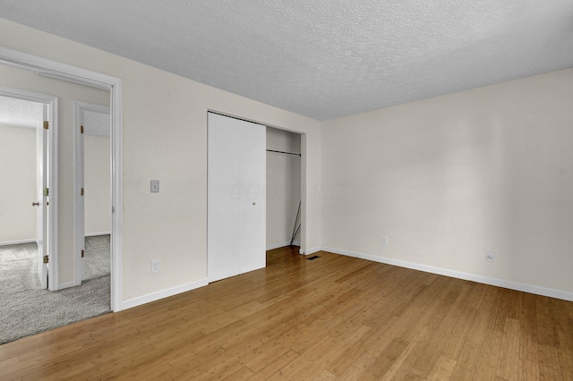 7879 Sudeley Ct, Westerville, OH 43081 - unfurnished bedroom featuring light wood finished floors, a textured ceiling, and a closet