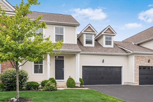 4609 Stoneworth Dr Unit 58, Hilliard, OH 43026 - view of front of property featuring a garage, roof with shingles, asphalt driveway, a front lawn, and stone siding
