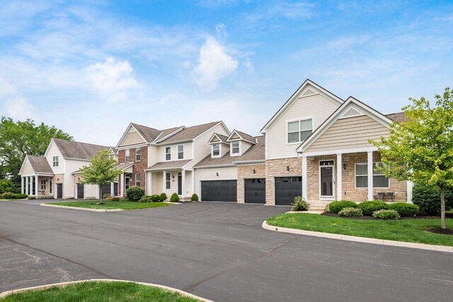 4609 Stoneworth Dr Unit 58, Hilliard, OH 43026 - view of property with driveway, stone siding, an attached garage, and a residential view