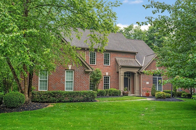 186 Cressingham Ln, Powell, OH 43065 - view of front of house with a front yard, brick siding, and a shingled roof