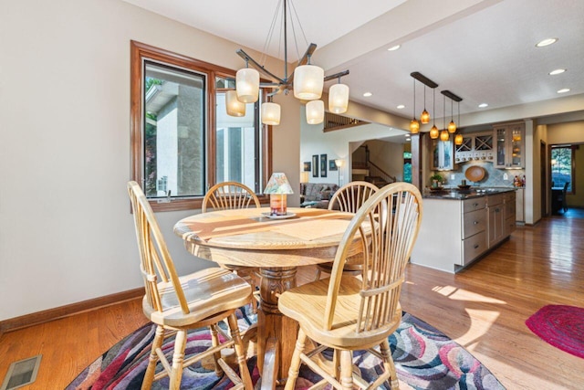 332 Waters Edge Dr, Hebron, OH 43025 - dining space featuring bar, recessed lighting, stairway, light wood-style floors, and a chandelier