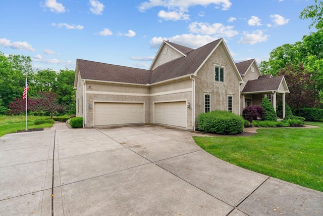 332 Waters Edge Dr, Hebron, OH 43025 - view of front of property with stucco siding, driveway, a front lawn, and a garage