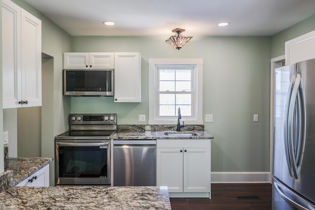 214 Moull St, Newark, OH 43055 - kitchen featuring stainless steel appliances, dark stone counters, white cabinetry, dark wood-style floors, and recessed lighting