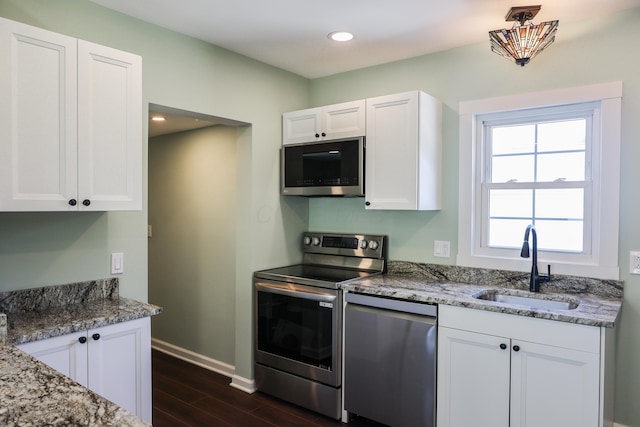 214 Moull St, Newark, OH 43055 - kitchen with appliances with stainless steel finishes, dark wood-style floors, light stone countertops, white cabinetry, and recessed lighting