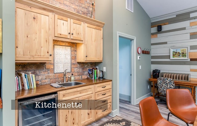525 Floral Valley Dr W, Howard, OH 43028 - kitchen with wine cooler, light brown cabinetry, backsplash, light wood finished floors, and a towering ceiling