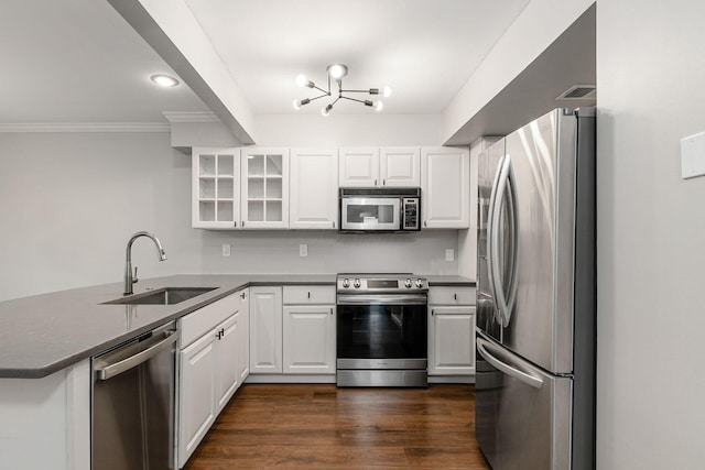 1573 Arlington Ave, Marble Cliff, OH 43212 - kitchen featuring stainless steel appliances, a sink, a peninsula, dark countertops, and glass insert cabinets