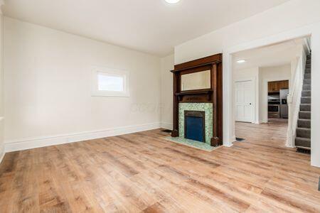 479 Siebert St, Columbus, OH 43206 - unfurnished living room with light wood-style flooring, a fireplace with flush hearth, and baseboards