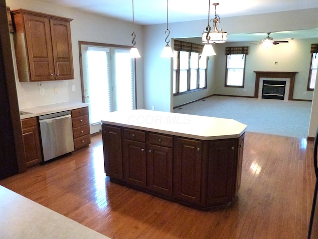 2360 Rufus Ct, Lewis Center, OH 43035 - kitchen featuring stainless steel dishwasher, wood finished floors, light countertops, and a glass covered fireplace