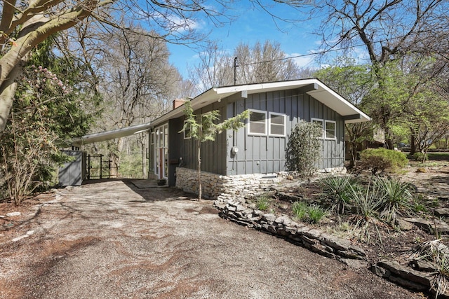 220 Hardy Way, Worthington, OH 43085 - view of side of home with board and batten siding, driveway, and a carport