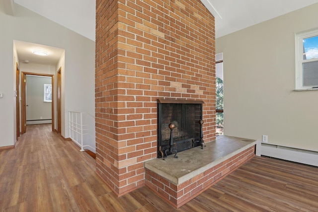 220 Hardy Way, Worthington, OH 43085 - unfurnished living room featuring baseboard heating, wood finished floors, plenty of natural light, and a brick fireplace