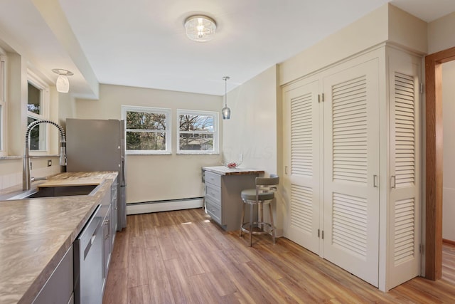 220 Hardy Way, Worthington, OH 43085 - kitchen featuring baseboard heating, stainless steel dishwasher, a sink, light wood-style flooring, and gray cabinets