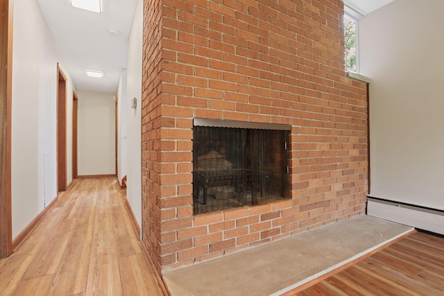 220 Hardy Way, Worthington, OH 43085 - detailed view of wood finished floors, a baseboard heating unit, a brick fireplace, and baseboards