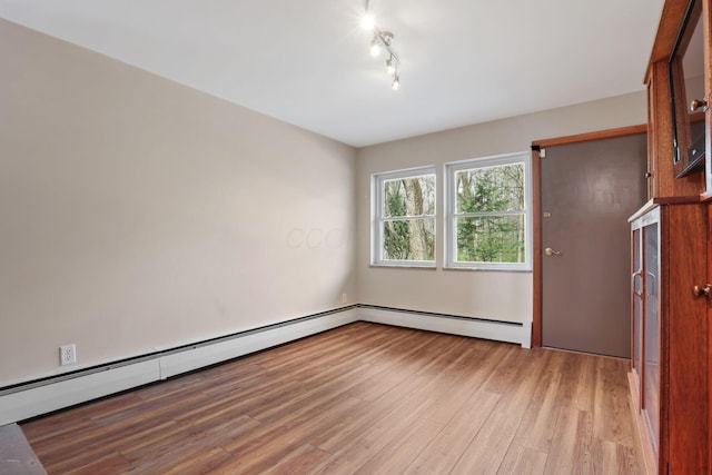 220 Hardy Way, Worthington, OH 43085 - empty room with light wood-style flooring, a baseboard radiator, and track lighting