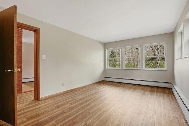 220 Hardy Way, Worthington, OH 43085 - empty room with a baseboard heating unit, light wood-style floors, and baseboards