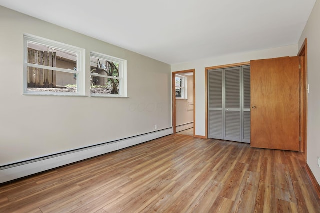 220 Hardy Way, Worthington, OH 43085 - unfurnished bedroom with wood finished floors, a baseboard heating unit, and a closet