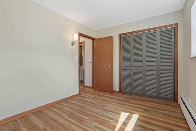 220 Hardy Way, Worthington, OH 43085 - unfurnished bedroom featuring a baseboard radiator, wood finished floors, a closet, and baseboards