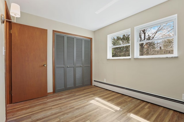220 Hardy Way, Worthington, OH 43085 - unfurnished bedroom with a baseboard heating unit, light wood-style flooring, and a closet