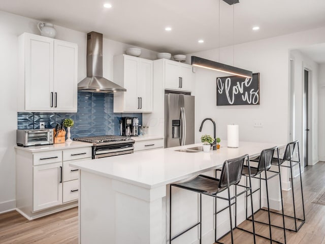1210 Madison Ave, Columbus, OH 43205 - kitchen with appliances with stainless steel finishes, wall chimney exhaust hood, light wood-style floors, backsplash, and white cabinetry