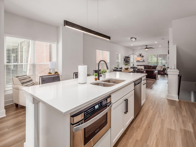 1210 Madison Ave, Columbus, OH 43205 - kitchen with stainless steel appliances, light wood finished floors, white cabinetry, light countertops, and open floor plan